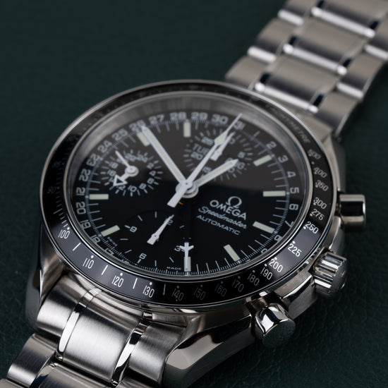 Omega Speedmaster Day-Date 3520.50 - close-up onder een lichte hoek met kroon en drukknoppen scherp in beeld