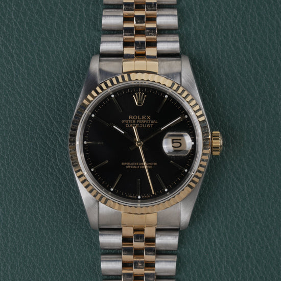 Rolex Datejust 16233 Black Dial 1991 - Volledig horloge recht van boven met zwarte wijzerplaat, gefacetteerde bicolor bezel en jubilee-band