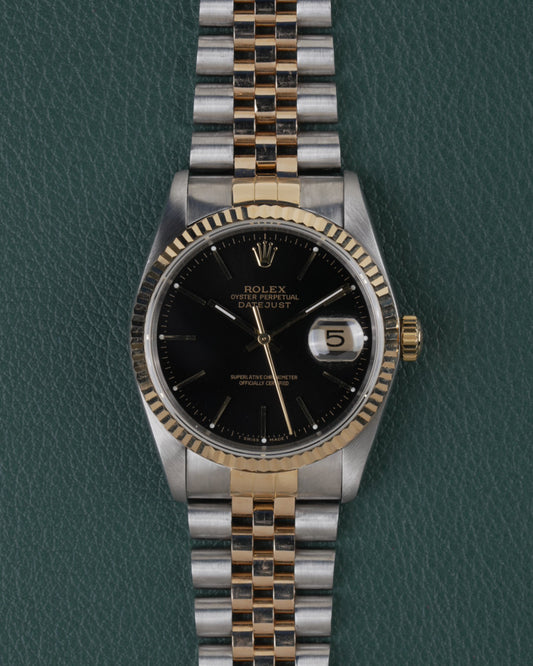 Rolex Datejust 16233 Black Dial 1991 - Volledig horloge recht van boven met zwarte wijzerplaat, gefacetteerde bicolor bezel en jubilee-band